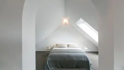 a bedroom with a bed in a white room at côté verger B&B in Battice