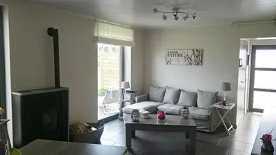 a living room with a couch and a fireplace at La renaissance in Villers-lʼÉvêque