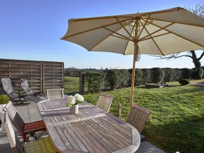 a wooden table with an umbrella and chairs at Limbourg Nature Retreat in Hèvremont