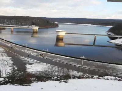a bridge over a river with snow on the ground at Limbourg Nature Retreat in Hèvremont
