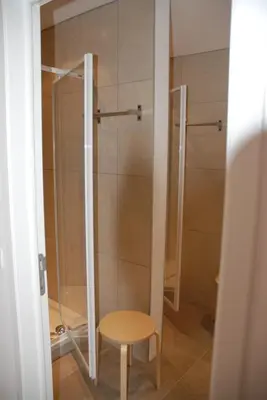 a shower with a wooden stool in a bathroom at La Balade d'Annie in Trooz