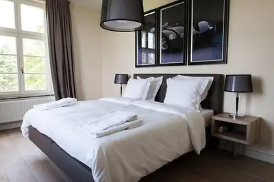 a bedroom with a large white bed with two towels on it at Château Charles in Pepinster