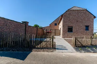 a fence in front of a brick building at Het Kloosterzicht in Borgloon