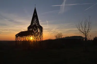 a tall building with the sunset in the background at 't Gillebroek in Borgloon