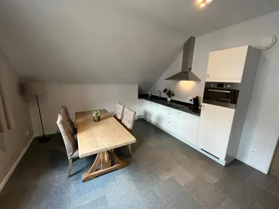 a kitchen with a table and chairs and a refrigerator at Bolderhuys in Bolderberg