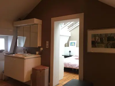 a bathroom with a sink and a bedroom with a bed at Tongeren Schuttersgang 1 in Tongeren