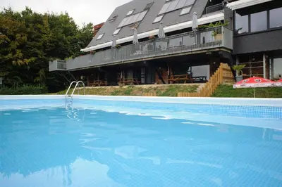 a large swimming pool in front of a building at Hostel De Veurs in Sint-Martens-Voeren