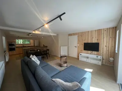 a living room with a blue couch and a television at Maison Léon in Bilstain