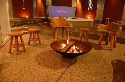 a fire pit in a room with chairs and a table at La Renaissance - Deux gites de standing in Herve