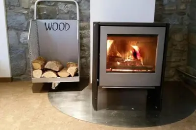a fireplace with bread in front of a stone wall at La Renaissance - Deux gites de standing in Herve