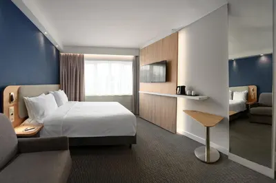 a hotel room with a bed and a couch at Holiday Inn Express Hasselt by IHG in Hasselt