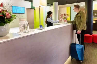 a man and a woman standing at a cash register at Holiday Inn Express Hasselt by IHG in Hasselt