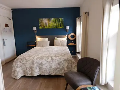 a bedroom with a bed and a blue wall at Hotel Restaurant The Kings Head Inn in Voeren