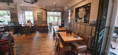 a restaurant with tables and people sitting at tables at Hotel Restaurant The Kings Head Inn in Voeren