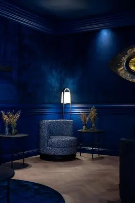 a blue room with a chair and two tables at La Butte aux Bois a Small Luxury Hotel of the World in Lanaken