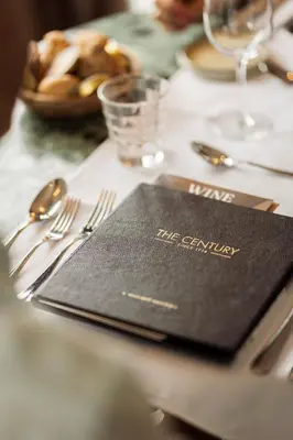 a black napkin sitting on top of a table with silverware at Hotel The Century in Hasselt
