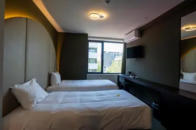 a hotel room with two beds and a window at Green Hotel in Genk