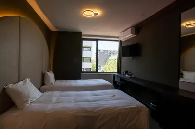 a hotel room with two beds and a window at Green Hotel in Genk