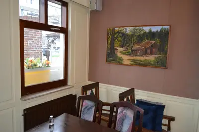 a dining room with a table and a painting of a barn at Hotel Plaza in Lommel