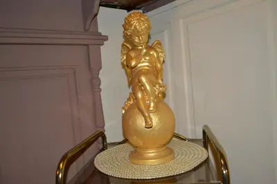 a gold statue of a woman sitting on a table at Hotel Plaza in Lommel