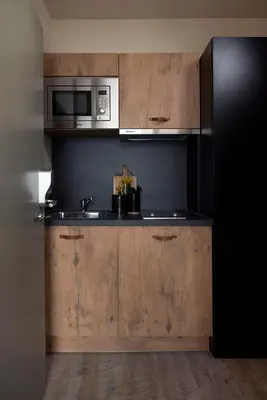 a kitchen with a sink and a microwave at Hotel Zuid in Genk