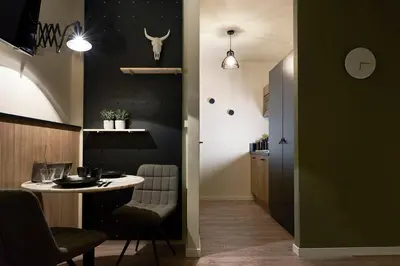 a dining room with a table and chairs and a room with a wall at Hotel Zuid in Genk