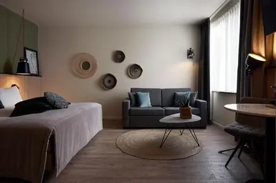 a living room with a bed and a couch at Hotel Zuid in Genk