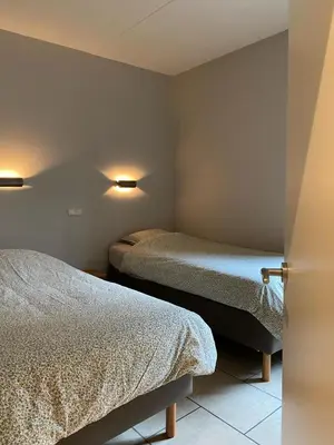 a room with two beds in a room with a door at d'Uyterwaerde in Leut