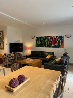 a living room with a table and a couch at d'Uyterwaerde in Leut