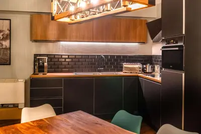 a kitchen with a table and chairs and a microwave at pentahotel Liège in Liège