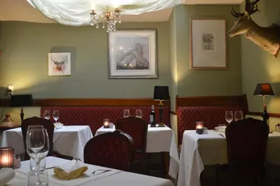 a dining room with tables and chairs with white table cloth at Hotel 'T Hert in Genk