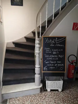 a stairway with a chalkboard sign next to a staircase at Hôtel Les Acteurs in Liège