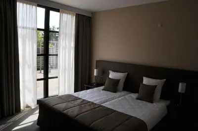 a bedroom with a bed and a large window at Hotel Boomgaard in Lanaken