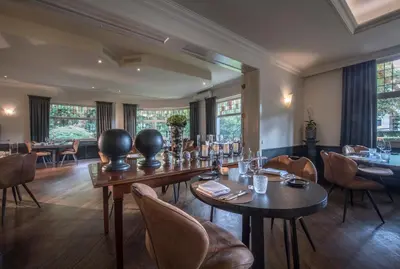 a dining room with tables and chairs and windows at Hotel Mardaga in As