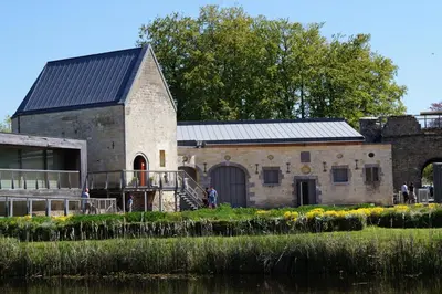 an old stone building next to a body of water at Eurotel Lanaken in Lanaken