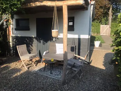 a pergola with a chair and a table at Belle Chique - Maastricht in Lanaken