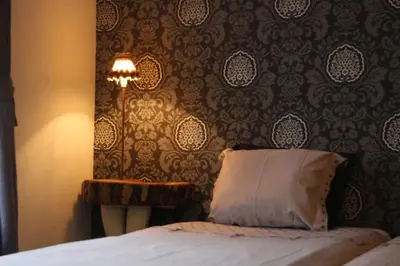 a bedroom with a bed with a pillow and a lamp at B&B Montenakerhof in Riemst