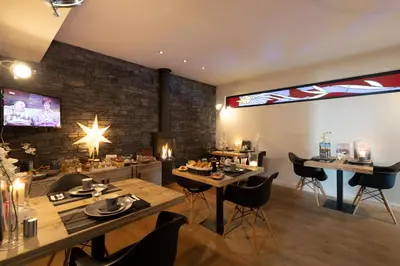 a restaurant with tables and chairs in a room at B&B Montenakerhof in Riemst