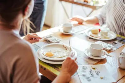a group of people sitting at a table eating eggs at Hotel Het Buskruid in Lummen