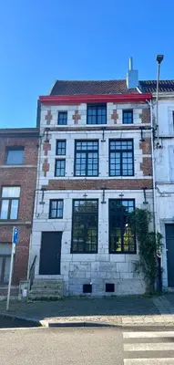 a large brick building with windows on a street at Maison Sainte-Marguerite in Liège