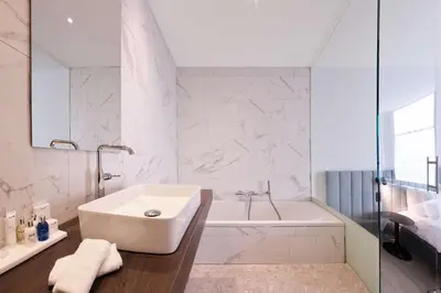 a white bathroom with a tub and a sink at Radisson Blu Hotel, Hasselt in Hasselt