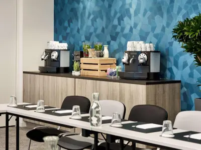 a meeting room with tables and chairs and a counter at Radisson Blu Hotel, Hasselt in Hasselt