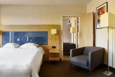 a hotel room with a bed and a chair at Park Inn by Radisson Liege Airport in Liège