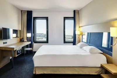a hotel room with a large bed and a desk at Park Inn by Radisson Liege Airport in Liège