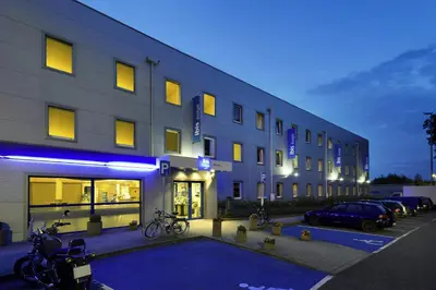a building with bikes parked in a parking lot at ibis budget Aachen Raeren Grenze in Raeren