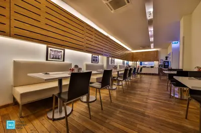 a dining room with tables and chairs and wooden floors at Hotel De La Couronne Liege in Liège