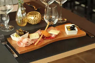 a plate of food on a table with wine glasses at Mezzo Hotel & Business in Beringen