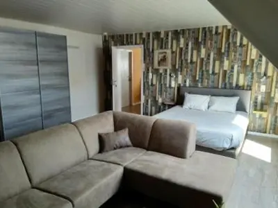 a living room with a couch and a bed at B&B Hoeven Het Gehucht in Overpelt