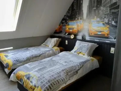 two beds in a room with a picture of taxis at B&B Hoeven Het Gehucht in Overpelt