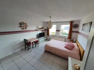 a bedroom with a bed and a desk and a table at Studio Filo in Liège